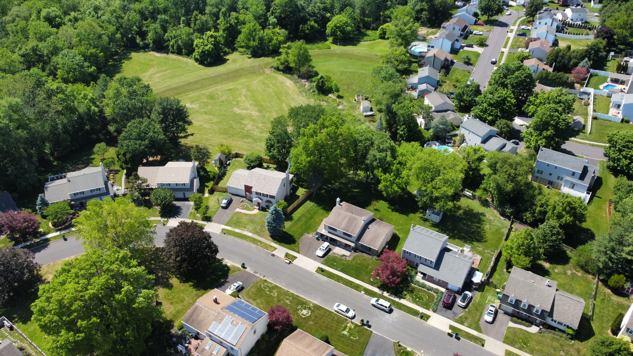 OwEmG angled aerial view showing residential homes and their surrounding neighborhood