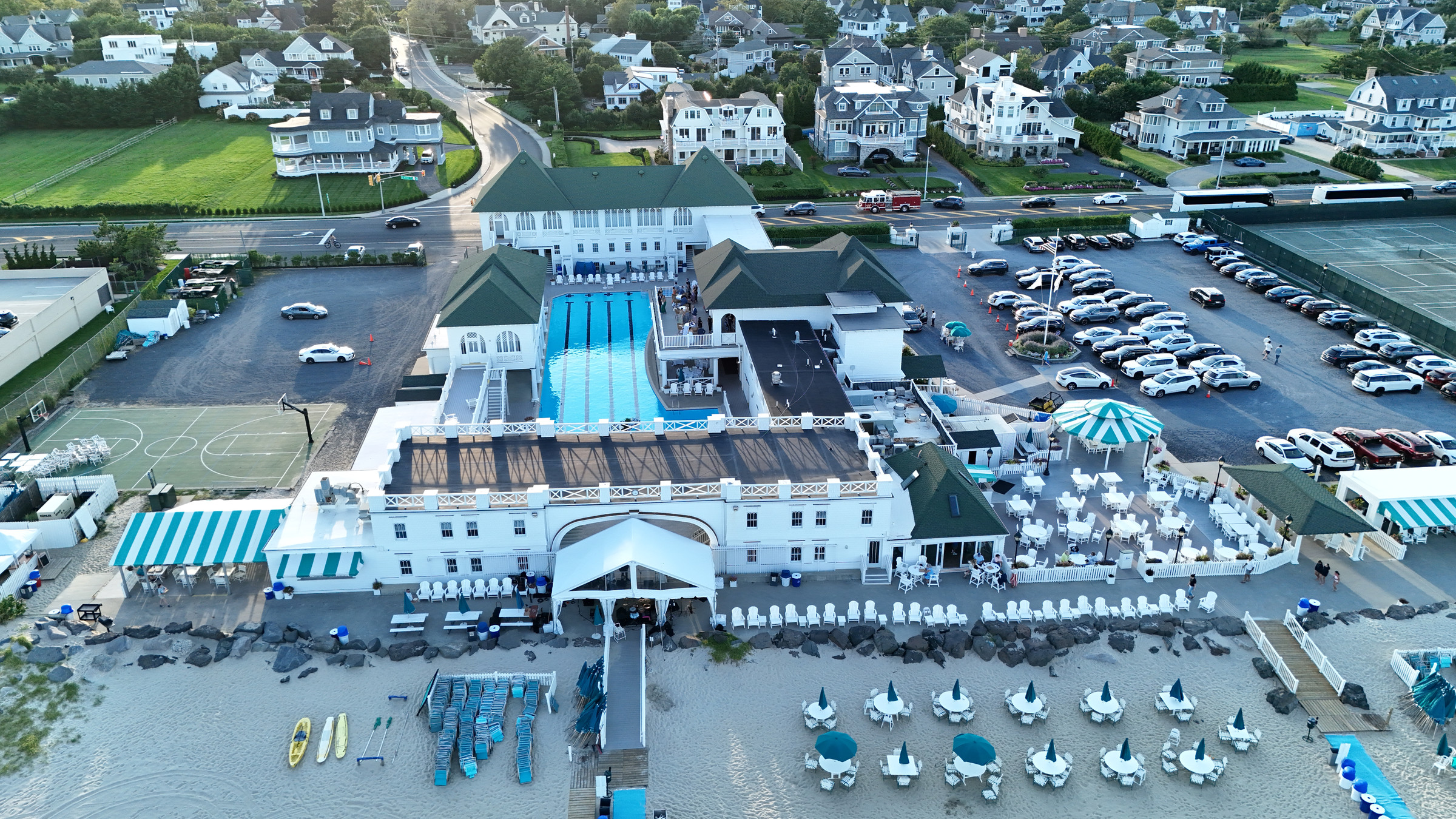 Aerial view of Monmouth Beach Bath & Tennis Club from the beach, showing its white facade and pool courtyard.